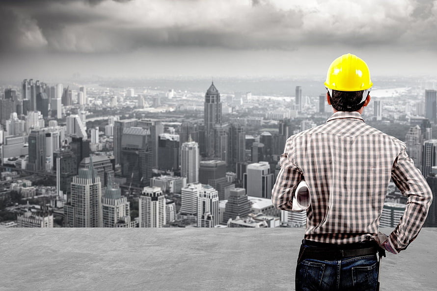 Civil Engineer in Yellow Hard Hat Overlooking City Skyline from Rooftop HD wallpaper