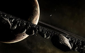 Saturn and its rings with a dense field of asteroids drifting through deep space HD wallpaper