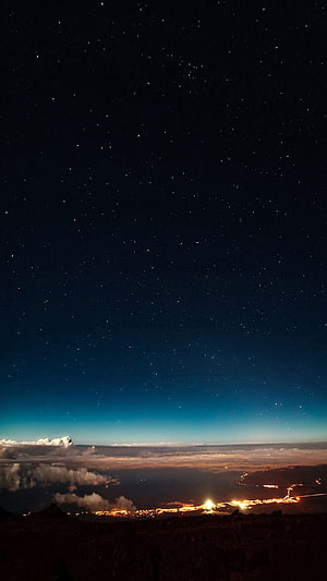 Starry Night Sky Above Clouds and Distant City Lights HD phone wallpaper