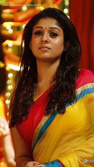 Nayanthara in a vibrant red and yellow sari with festive bokeh lighting HD phone wallpaper