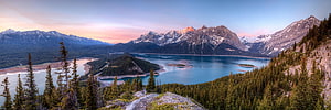 Panoramic View of a Turquoise Mountain Lake at Sunset with Snow-Capped Peaks HD wallpaper