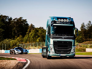 Volvo FH16 Globetrotter and Koenigsegg Supercar Racing on a Track HD wallpaper
