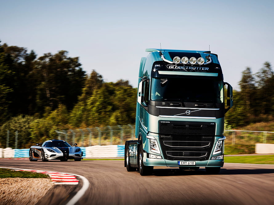 Volvo FH16 Globetrotter and Koenigsegg Supercar Racing on a Track HD wallpaper