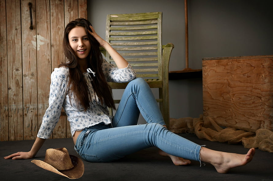 Alisa Amore in a rustic studio setting wearing a floral blouse and blue jeans with a straw hat HD wallpaper