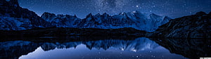 Starry Night Sky Over Snow-Capped Mountains Reflected in a Calm Alpine Lake HD wallpaper
