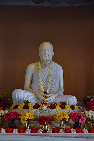 Sri Ramakrishna Statue at Belur Math Surrounded by Vibrant Floral Offerings HD phone wallpaper