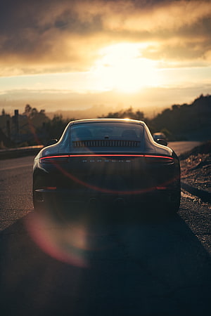 Rear View of a Black Porsche 911 on a Road at Golden Hour Sunset HD phone wallpaper