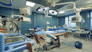 Modern Operating Room with Surgical Table and Overhead Lighting Equipment HD wallpaper