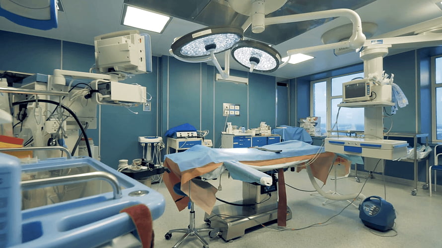 Modern Operating Room with Surgical Table and Overhead Lighting Equipment HD wallpaper