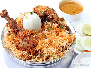 Traditional Chicken Biryani with boiled egg and raita served in a metal bowl HD wallpaper