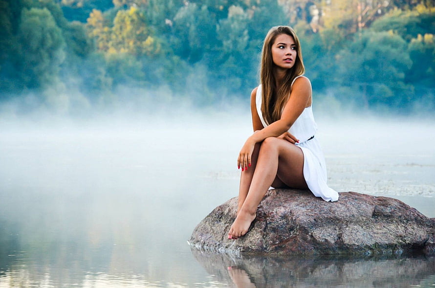 Woman in white dress sitting on a rock in a misty lake surrounded by forest, Brunette, girl, model, people, woman HD wallpaper