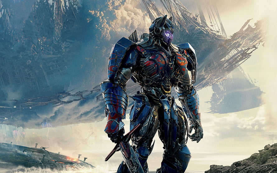 Optimus Prime in battle armor standing before a massive alien warship in a post-apocalyptic landscape HD wallpaper