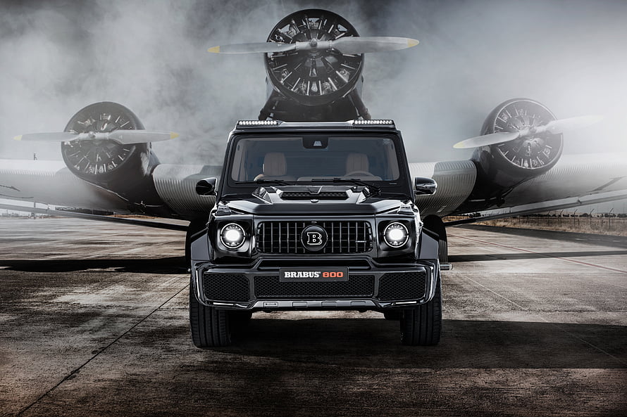 Black Brabus 800 Widestar SUV Parked in Front of Vintage Propeller Aircraft HD wallpaper