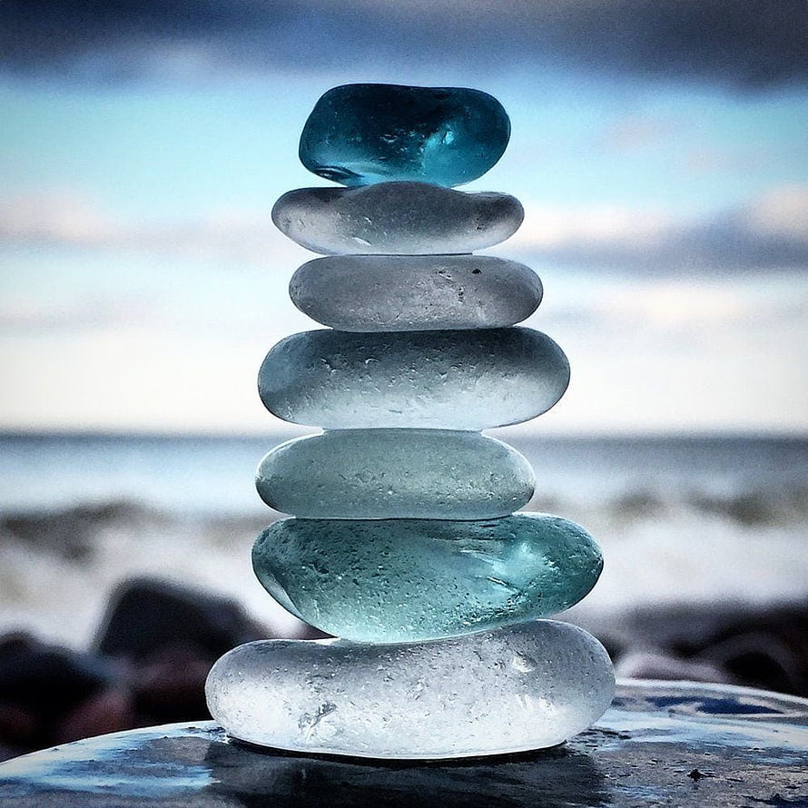 Stacked Sea Glass Stones on a Beach with Ocean Horizon and Soft Sky HD phone wallpaper