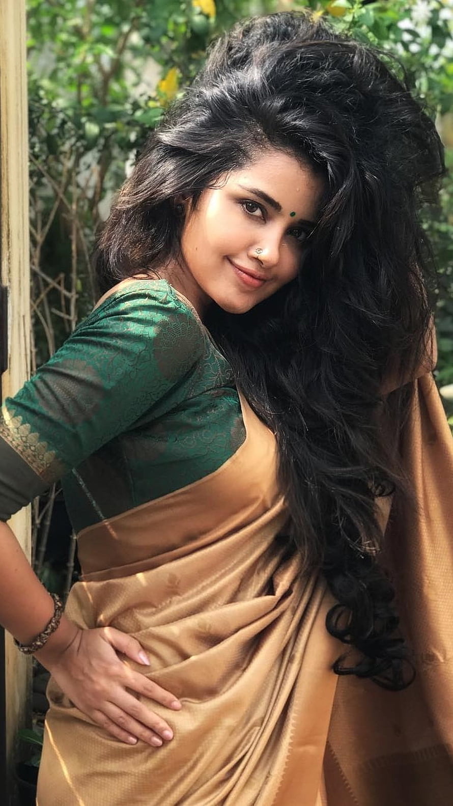 Anupama Parameswaran in a Green and Gold Saree with Long Wavy Hair HD phone wallpaper