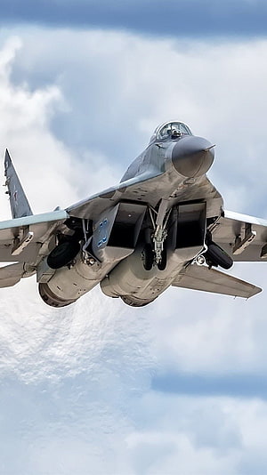 Mikoyan MiG-29 Fulcrum Fighter Jet in Flight with Landing Gear Extended Against Cloudy Sky HD phone wallpaper