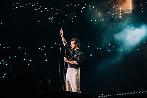 Harry Styles performing live on stage with dramatic lighting and smoke effects HD wallpaper