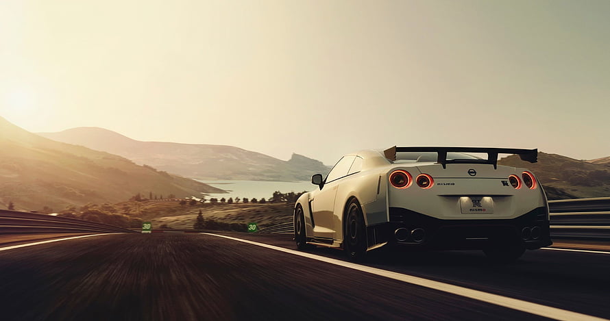 White Nissan GT-R Nismo R35 Cruising on a Scenic Mountain Highway at Sunset HD wallpaper