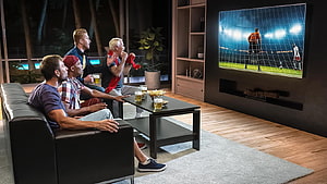 Friends Watching Soccer Match On Large Wall-Mounted TV In Modern Living Room HD wallpaper