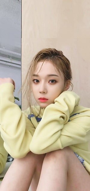 Winter from aespa in a soft yellow hoodie with a relaxed indoor pose HD phone wallpaper
