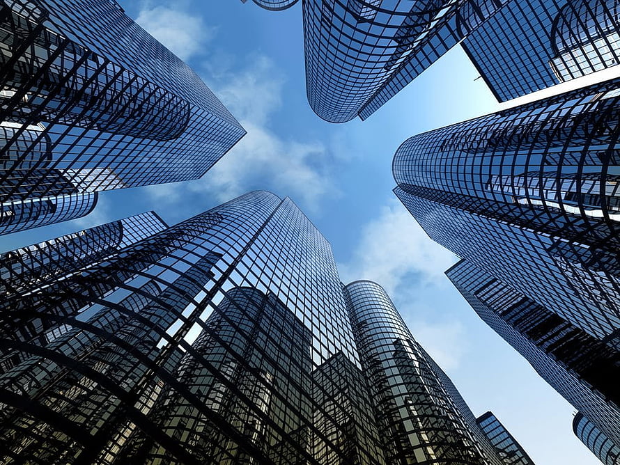Low-angle view of modern glass skyscrapers converging against a blue sky with scattered clouds HD wallpaper