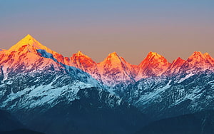 Snow-Capped Mountain Range Bathed in Golden Sunrise Light HD wallpaper