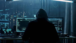 Hooded Hacker Silhouette at Multi-Monitor Cyber Defense Command Center HD wallpaper