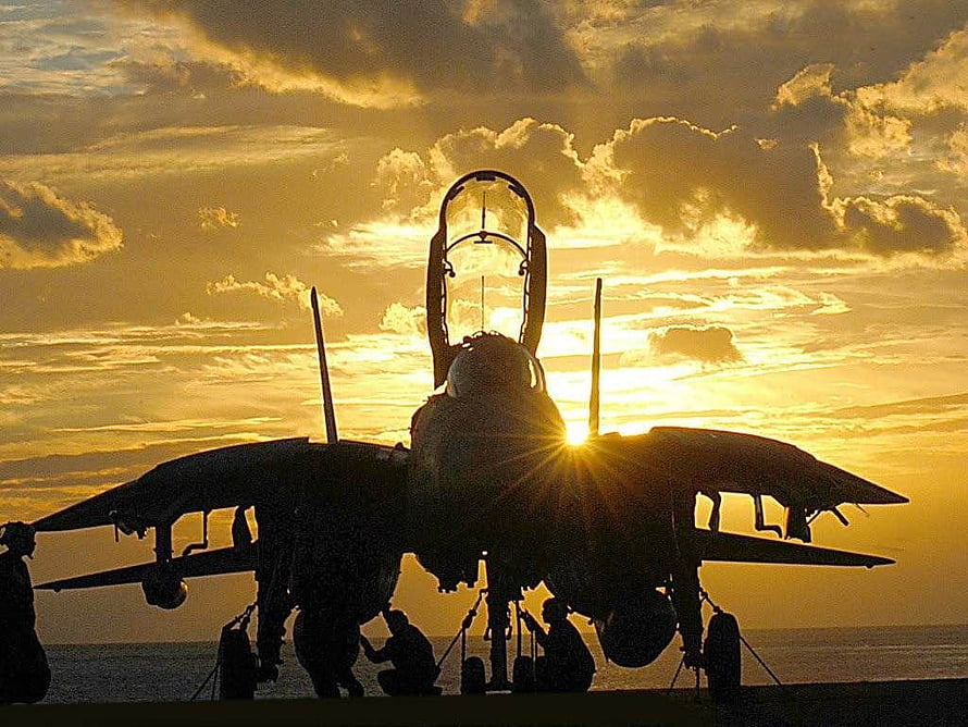 F-14 Tomcat fighter jet silhouette on carrier deck at golden sunset HD wallpaper