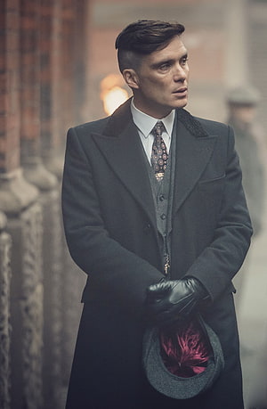 Cillian Murphy as Thomas Shelby in Peaky Blinders wearing a dark overcoat and holding a flat cap HD phone wallpaper