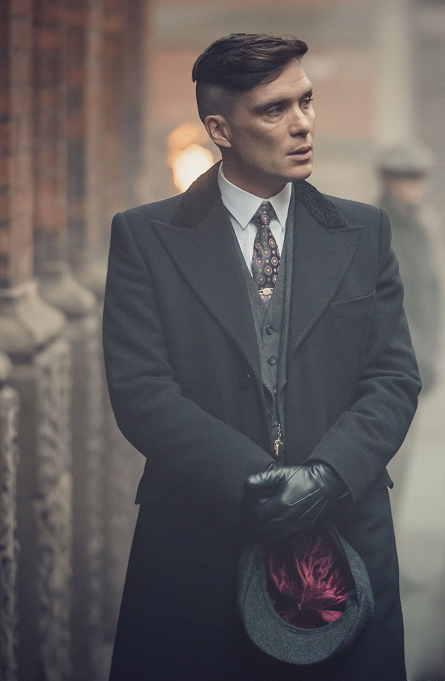 Cillian Murphy as Thomas Shelby in Peaky Blinders wearing a dark overcoat and holding a flat cap HD phone wallpaper