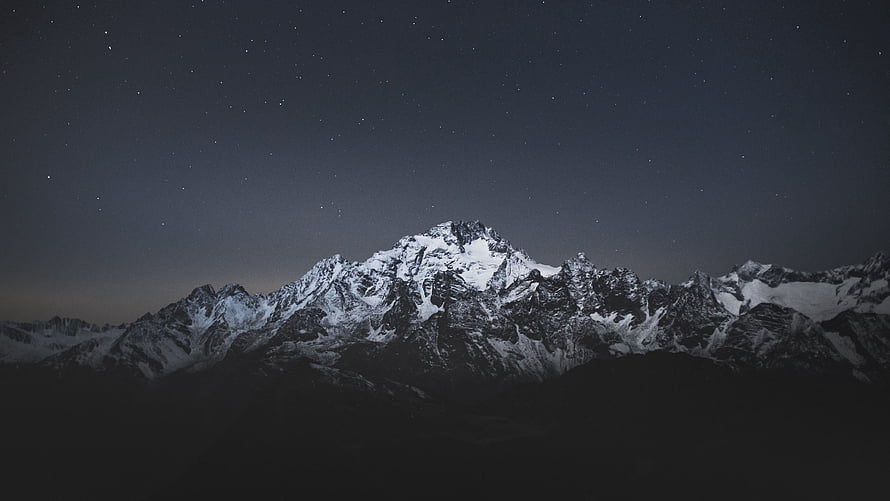 Snow-Capped Mountain Range Under a Starry Night Sky HD wallpaper