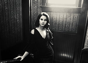 Lana Del Rey in a black dress against vintage wallpaper in a moody monochrome portrait HD wallpaper