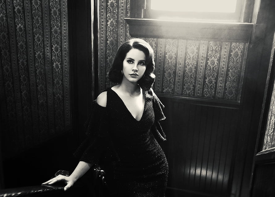 Lana Del Rey in a black dress against vintage wallpaper in a moody monochrome portrait HD wallpaper