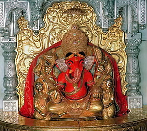 Siddhivinayak Ganesha Murti with Ornate Gold Carvings and Red Drapery HD wallpaper