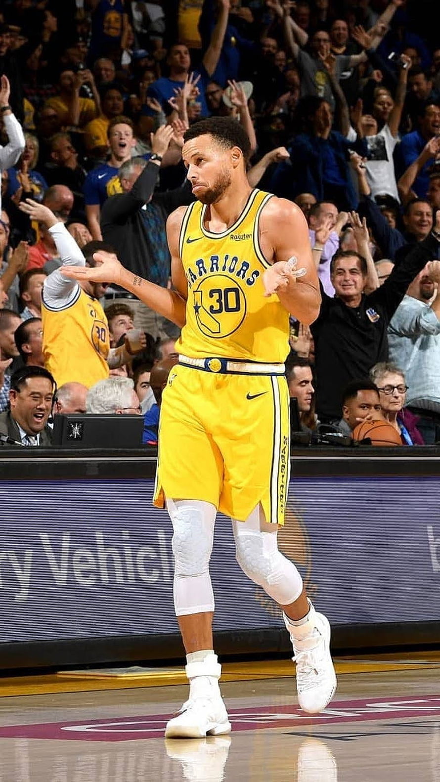 Stephen Curry in Golden State Warriors yellow jersey celebrating on the basketball court HD phone wallpaper