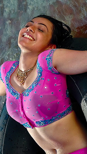 Kajal Agarwal in a vibrant pink embellished crop top with a gold necklace, smiling with eyes closed HD phone wallpaper