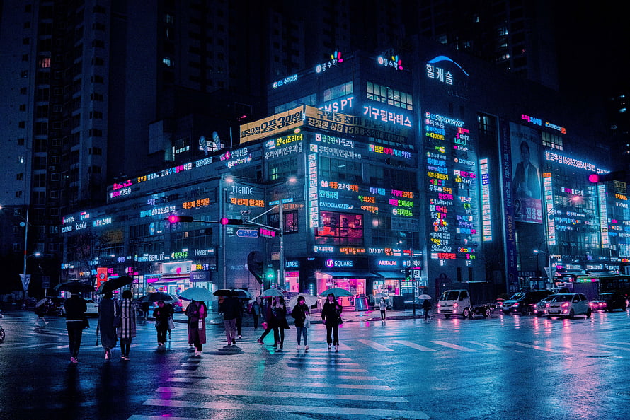 Neon-lit Seoul street at night with pedestrians crossing in the rain HD wallpaper