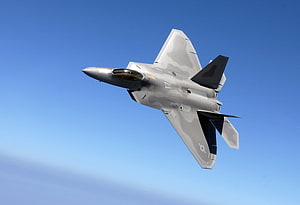 Lockheed Martin F-22 Raptor Stealth Fighter Jet Banking Through Clear Blue Sky HD wallpaper