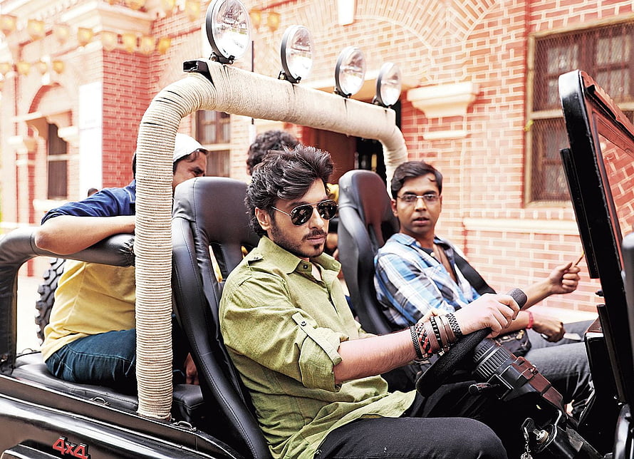 Munna Bhaiya in a rugged 4x4 vehicle with crew in front of a red brick building HD wallpaper
