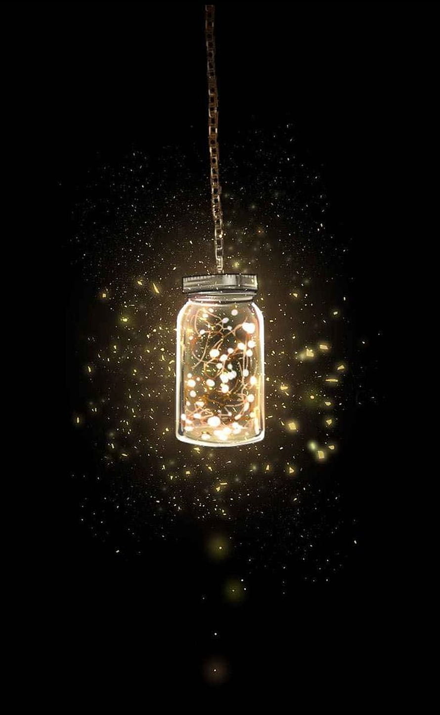 Glowing Fairy Light Jar Hanging Against a Dark Background with Golden Sparkles HD phone wallpaper