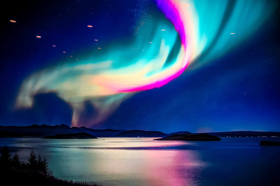Vivid Aurora Borealis Dancing Over a Serene Icelandic Fjord at Night HD wallpaper