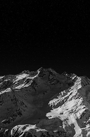 Snow-Capped Alpine Peaks Under a Star-Filled Night Sky HD phone wallpaper