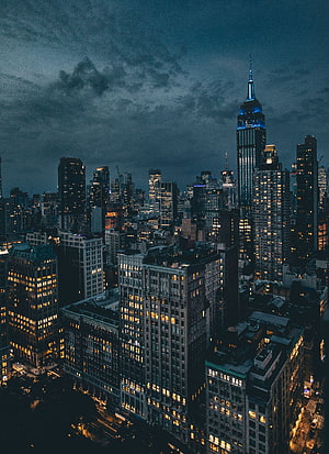 New York City Skyline at Night with Empire State Building and Dramatic Clouds HD phone wallpaper
