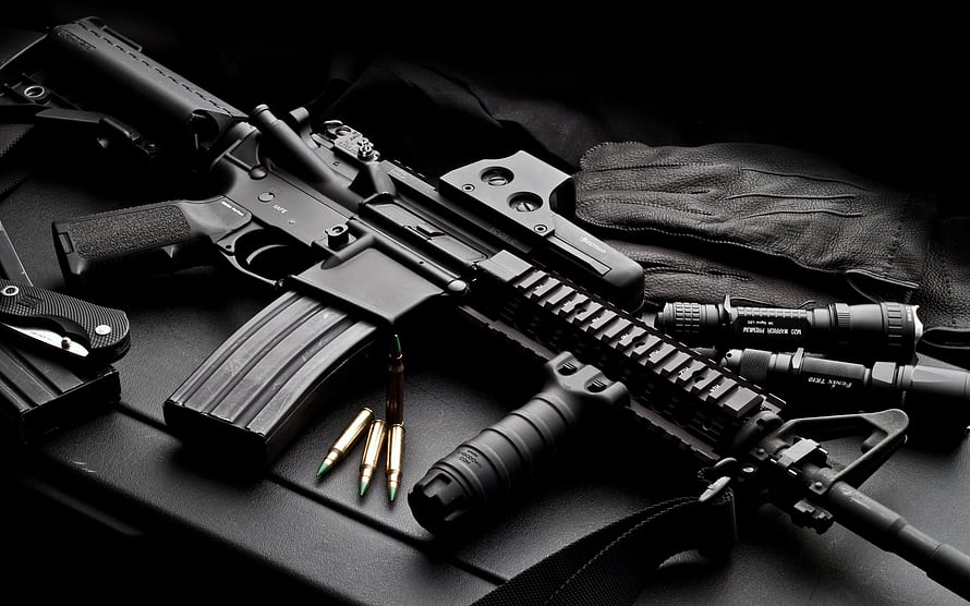 Black Tactical AR-15 Rifle with Ammunition and Gear on Dark Surface HD wallpaper