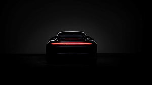 Porsche 911 Turbo S Rear View with Glowing Light Bar in Dark Studio Setting HD wallpaper