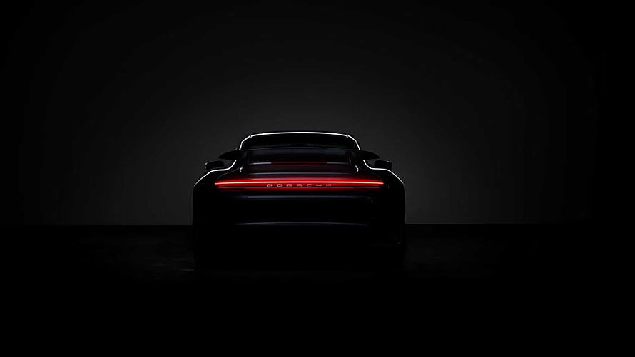 Porsche 911 Turbo S Rear View with Glowing Light Bar in Dark Studio Setting HD wallpaper