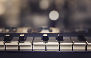 Close-up of piano keys with a softly blurred studio background and warm bokeh lighting HD wallpaper