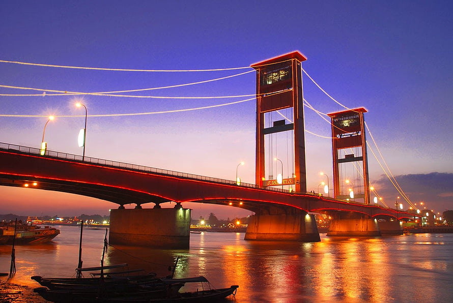 Ampera Bridge in Palembang at Dusk with Red Illumination and River Reflections HD wallpaper
