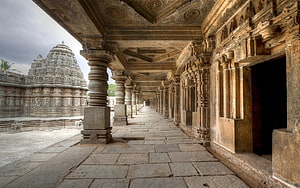 Ancient Hindu Temple Corridor With Intricate Stone Carvings And Shikhara Spire HD wallpaper