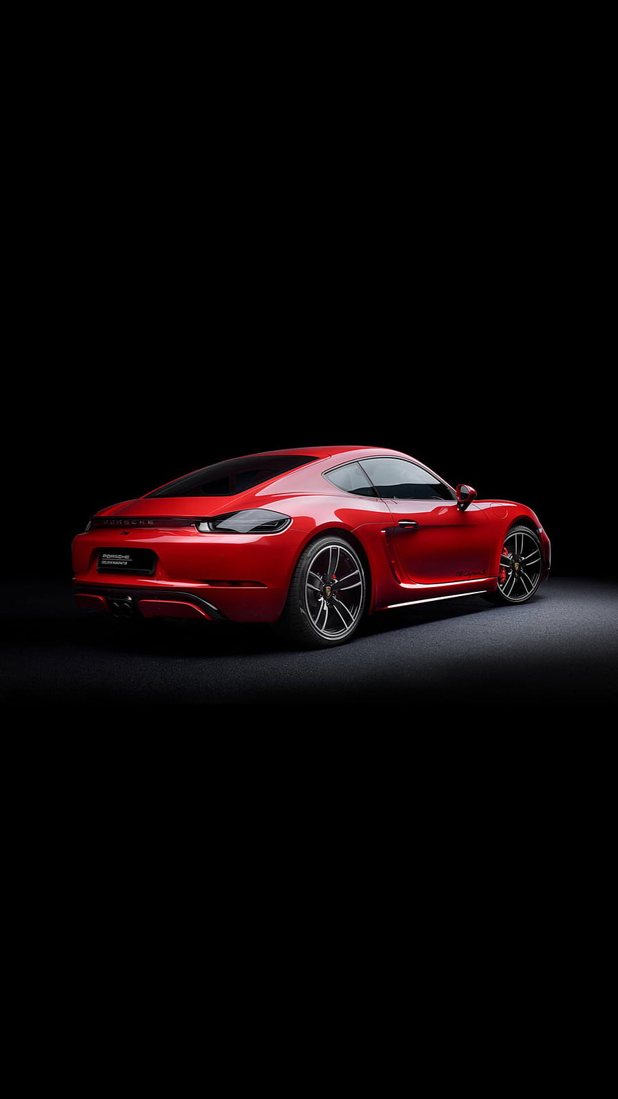 Red Porsche 718 Cayman sports car in a dark studio setting HD phone wallpaper